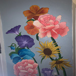This image is of a painting on a wall with pink, blue, purple, and yellow flowers. 