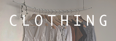 Clothes hanging on rack with white letters saying clothing