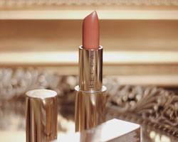 Becca Cosmetics nude pink lipstick product.