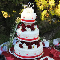 A triple-layer cake with roses on top of each layer with an intwined hearts cake topper. Click here for a larger picture.