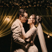 Newly married couple dances close in the evening.