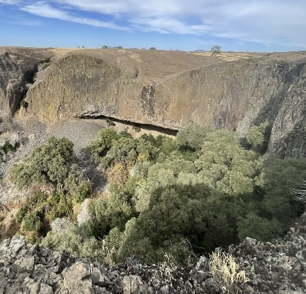 Top view of a cave crevice and overview of the ravine