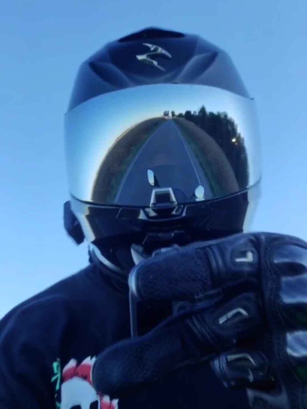 Trey giving a peace sign while wearing motorcycle gear.