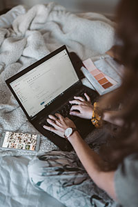 Person working on their laptop with blankets and color swatches