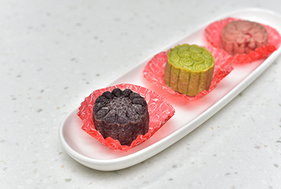 Three mooncakes in red, green, and black