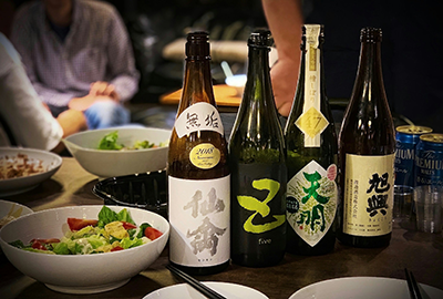 Assorted bottles of premium sake with small tasting cups