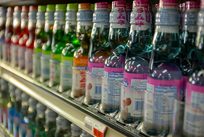 Shelf full of colorful Ramune bottles in various fruit flavors