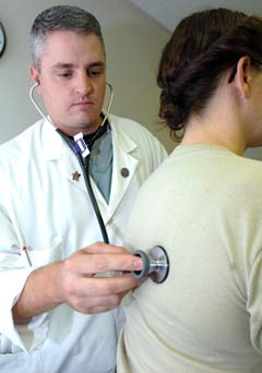 doctor using stethoscope on patient