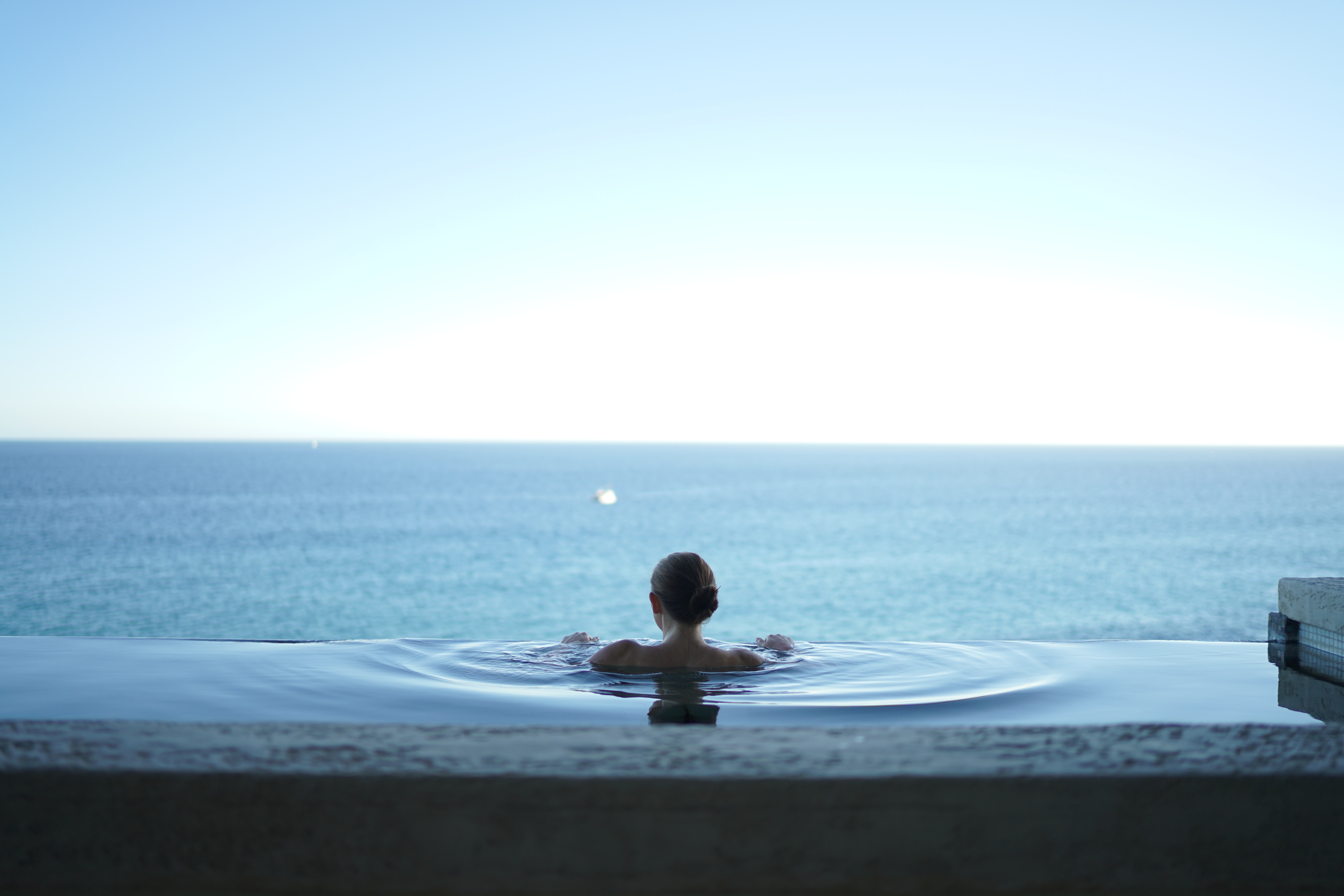 girl looking out at the ocean in a pool