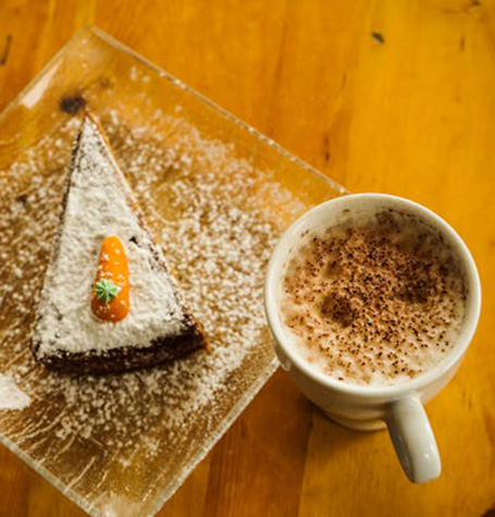 picture of a slice of cake and coffee with cinnamon on top