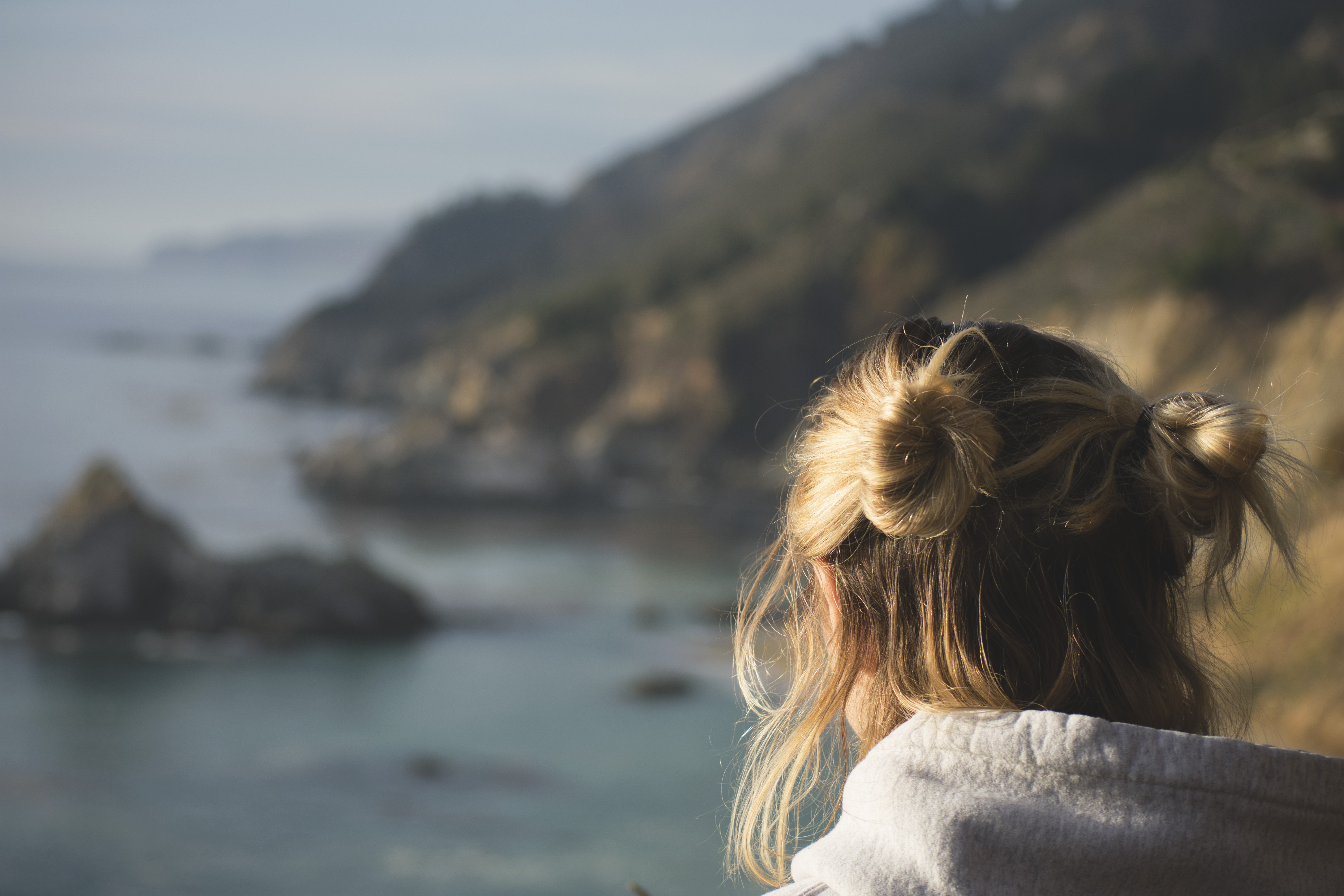 Blonde woman looking over the California coastline