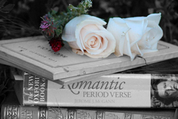  Literature books in black and white with color flowers on top of them. 